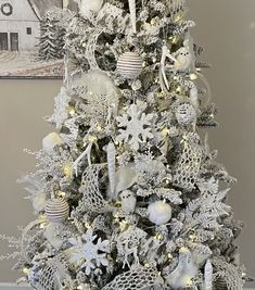 a white christmas tree decorated with ornaments and lights