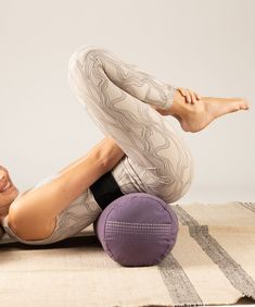 a woman laying on the floor with her legs up