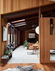 an open living room and dining area with wood paneling