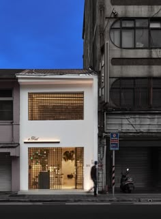 an empty street in front of two tall buildings with shutters on the doors and windows