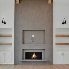 a fire place in the middle of a room with shelves on either side and an open fireplace