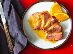 a white plate topped with meat and orange slices