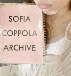 a woman holding up a pink sign that says sofia coppola archive