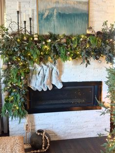 a fireplace decorated with greenery and stockings