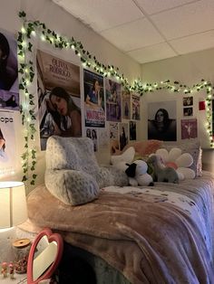 a bedroom decorated for christmas with pictures on the wall and lights strung from the ceiling