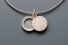 This small locket for one picture is handmade in solid sterling silver. The  secret locket only reveals the treasure inside, when you slide the lid to the side. But you can also keep it hidden and just show the minimalist dot pattern, that decorates the lid of the pendant. Locket for one picture - diameter 14mm (0,55")- thickness: ca. 3mm (0,13") - design: little dots  - Sterling Silver How it works: * The lockets consist of two movable parts, fitting tightly together. * You have to push the lid Minimalist Sterling Silver Locket Pendant Necklace, Minimalist Sterling Silver Locket Necklace Gift, Sterling Silver Minimalist Locket Necklace As Gift, Everyday Sterling Silver Locket Necklace, Silver Minimalist Locket Necklace For Everyday, Everyday Silver Locket Necklace, Silver Minimalist Locket Necklace, Minimalist Sterling Silver Locket Necklace, Minimalist Silver Locket Necklace With Round Pendant