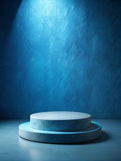 a round white pedestal with a blue light on the wall behind it in a dark room