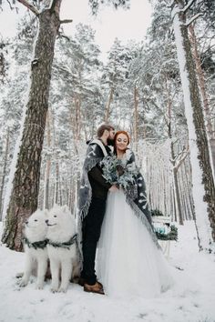 a bride and groom are standing in the snow with their dog next to each other