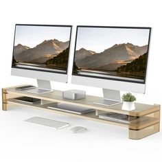 two computer monitors sitting next to each other on top of a wooden desk with keyboard and mouse