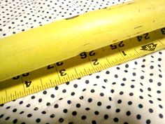 a yellow banana sitting on top of a white and black polka dot blanket next to a measuring tape