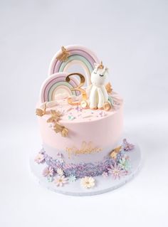 there is a pink cake with a unicorn on top