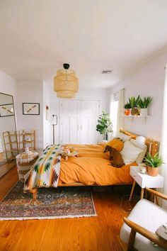 a bed room with a neatly made bed and lots of plants on the wall next to it