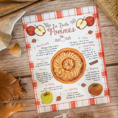 an apple pie recipe on a table with autumn leaves and pumpkins around the perimeter