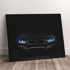 a black bmw car with blue lights on it's headlight is shown in front of a white wall