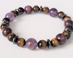 "This is a Men's bracelet, Super seven bracelet, Super seven Tiger eye, energy bracelet, stretchy bracelet, heal stone, energy gemstone, Hematite, unisex bracelet. Material : Genuine gemstone Length : 17.8cm (7\" ) Weight : 26g (0.9oz) The details of the gemstone are Super Seven round 10mm x7,  Tiger eye round 8mm x14, Hematite Rondelle 6mmx8mm x7. CumisGems men's bracelet  https://www.etsy.com/shop/CumisGems?ref=seller-platform-mcnav&section_id=15730953" Stone Energy, Eye Round, Energy Bracelets, Tiger Eye Bracelet, Diffuser Bracelets, Men's Bracelet, Hematite Beads, Unisex Bracelets, Stretchy Bracelets