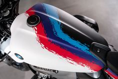 a close up view of the front end of a motorcycle with red, white and blue paint splattered on it