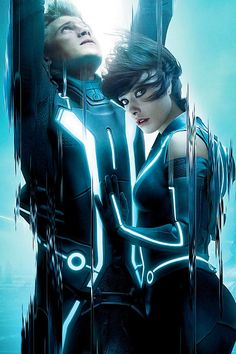 a man and woman in futuristic garb standing next to each other with their arms around each other