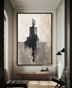 an abstract painting hangs on the wall above a bench in a room with white walls