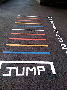 an empty parking lot with colorful lines painted on the ground and white writing that says, pmu