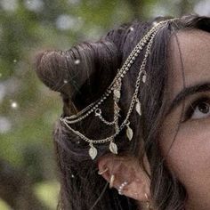 a woman with horns and chains on her head is staring at something in the distance