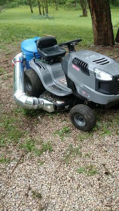 a lawn mower sitting on the ground next to a tree