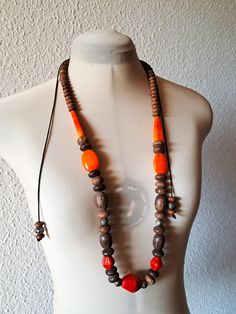 This statement, massive necklace has large stones in red and orange and wood beads of different size. A large diamand shape large stone sits at the bottom which adds boldness. It is hand strung and tied with ties. This necklace in excellent used condition. Measuriments: total length - 168 cm/ 66'' with ties size large stone beads - 4cm/1.6'' and 3 cm/ 1.2'' Unique Orange Jewelry With Wooden Beads, Unique Orange Necklace With Wooden Beads, Orange Wooden Beads For Festival, Orange Wooden Beads For Festivals, Orange Wooden Beads Jewelry For Festival, Bohemian Orange Necklaces With Wooden Beads, Bohemian Orange Necklace With Wooden Beads, Adjustable Orange Necklace With Wooden Beads, Orange Large Beaded Necklace For Festivals