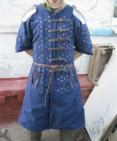 a man dressed in an old fashioned blue outfit with white studs on his chest