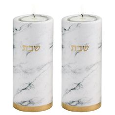 two white marble candles with gold lettering on them