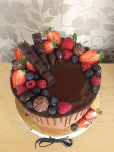 a chocolate cake with strawberries, raspberries, and chocolate on the top