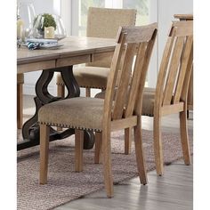 a dining room table and chairs with a rug on the floor in front of it