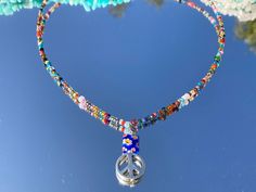 This beaded choker is made with colorful seed beads and a silver peace sign with a square bead. It is super cute and dainty and does give off a Beachy feel. It's simple and makes a great gift for others or yourself! INCLUDES: ♥ One beaded choker * for best wear I wouldn't recommend wearing this item to sleep, or in any type of water **Each necklace is unique and bead colors vary for each necklace *PLEASE CHOOSE THE CORRECT MEASUREMENT BEFORE PURCHASING ♥Follow us on INSTAGRAM @Lifeonocean_ and T Artsy Handmade Beaded Necklaces For Festivals, Handmade Artsy Beaded Necklace For Festivals, Handmade Spiritual Choker For Festivals, Handmade Hippie Beaded Necklace For Festivals, Hippie Beaded Necklace For Festivals, Hippie Beaded Choker Necklace As Gift, Hippie Style Adjustable Beaded Choker Necklace, Hippie Beaded Choker Necklace For Festivals, Adjustable Hippie Choker For Festivals