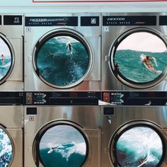 four washing machines with people in the water and one person on a surfboard behind them