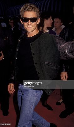 an image of a man in sunglasses walking on the red carpet with people behind him