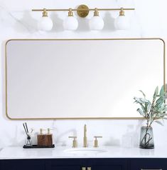 a bathroom vanity with a large mirror and two faucets on the wall above it