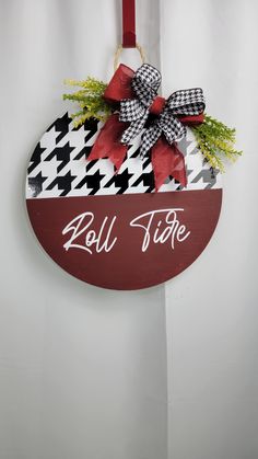 a red and white sign hanging from the side of a wall with a bow on it