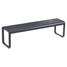 a black bench sitting on top of a white wall