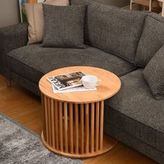 a coffee table sitting on top of a wooden floor next to a gray sectional couch