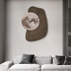 a living room with a couch and large clock on the wall