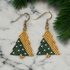 Add a touch of elegance and bohemian charm to your look with our exquisite handmade seed bead earrings. Each pair is meticulously crafted with love and attention to detail, ensuring that no two pairs are exactly alike. These earrings make a thoughtful and unique gift for birthdays, anniversaries, or just because. Dark green and gold trees with white accents Made with high quality seed beads. Gold filled ear wires 2.4 x 3 cm. Packed in a velveteen gift bag.  Ready to ship. This is not an original Wreath Beaded Earrings, Beaded Christmas Tree Earrings, Art Nouveau Christmas, Triangle Beaded Earrings, Earring Inspired, Xmas Beads, Beaded Christmas Tree, Christmas Tree Beads, Stitch Earrings