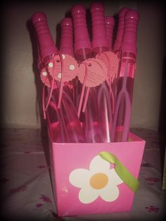 pink plastic utensils are sitting in a pink flower - shaped box on a table