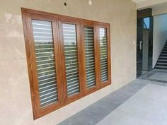 an empty room with wooden shutters on the outside and stairs leading up to it