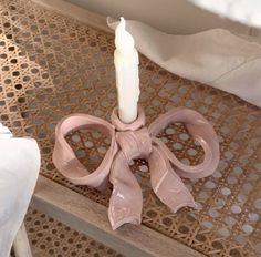 a pink candle holder sitting on top of a wooden table