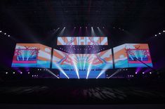 the stage is set up for an event with large screens on each side and bright lights