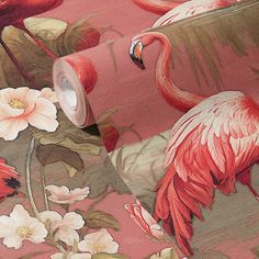 a pink flamingo wallpaper with flowers and leaves on the background, it has a roll of toilet paper in front of it