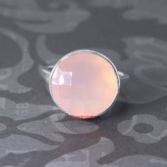 Rose Quartz 925 sterling silver Ring / Bezel set Round Shape Gemstone Ring / Handmade Ring / Gift for Her Ring / Wedding Ring Product / Item Details:  Product Type: Ring Product Quantity: 1 Ring Used Metal: 925 Sterling Silver Metal Purity: Solid 925 Metal Color: Silver Gemstone : Pink Chalcedony Gemstone Size: 14mm Round Shape Product Weight: 5.000 grams Approx Listing is For One (1 item) All are designed and handmade by me and my team with precision, Perfect craftsmanship and strong interest! We are continuously adding new products in our etsy shop, So please keep coming back to see more great deals on jewelry in our store! For Wholesale orders or custom made order requirements, please feel free to contact me! Thank you so much for visiting! Pink Sterling Silver Crystal Ring, Pink Moonstone Sterling Silver Ring For Anniversary, Silver Faceted Moonstone Wedding Ring, Silver Faceted Moonstone Ring For Wedding, Faceted Silver Moonstone Wedding Ring, Pink Round Moonstone Ring For Gift, Pink Moonstone Ring Gift, Sterling Silver Faceted Crystal Ring, Silver Moonstone Ring With Bezel Setting As Gift