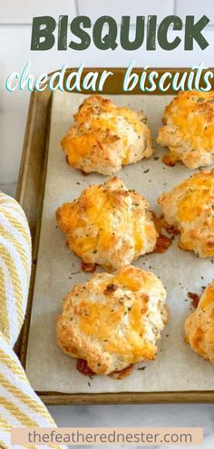 biscuits on a baking sheet with the words bisquick cheddar biscuits above them