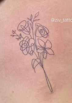 a woman's stomach has a tattoo with flowers on the side, and an arrow