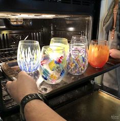 three glasses sitting on top of an open oven