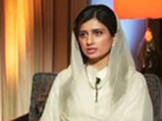 a woman wearing a white shawl sitting in a chair