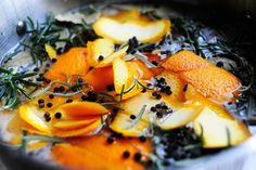 oranges, rosemary and black pepper cooking in a pan